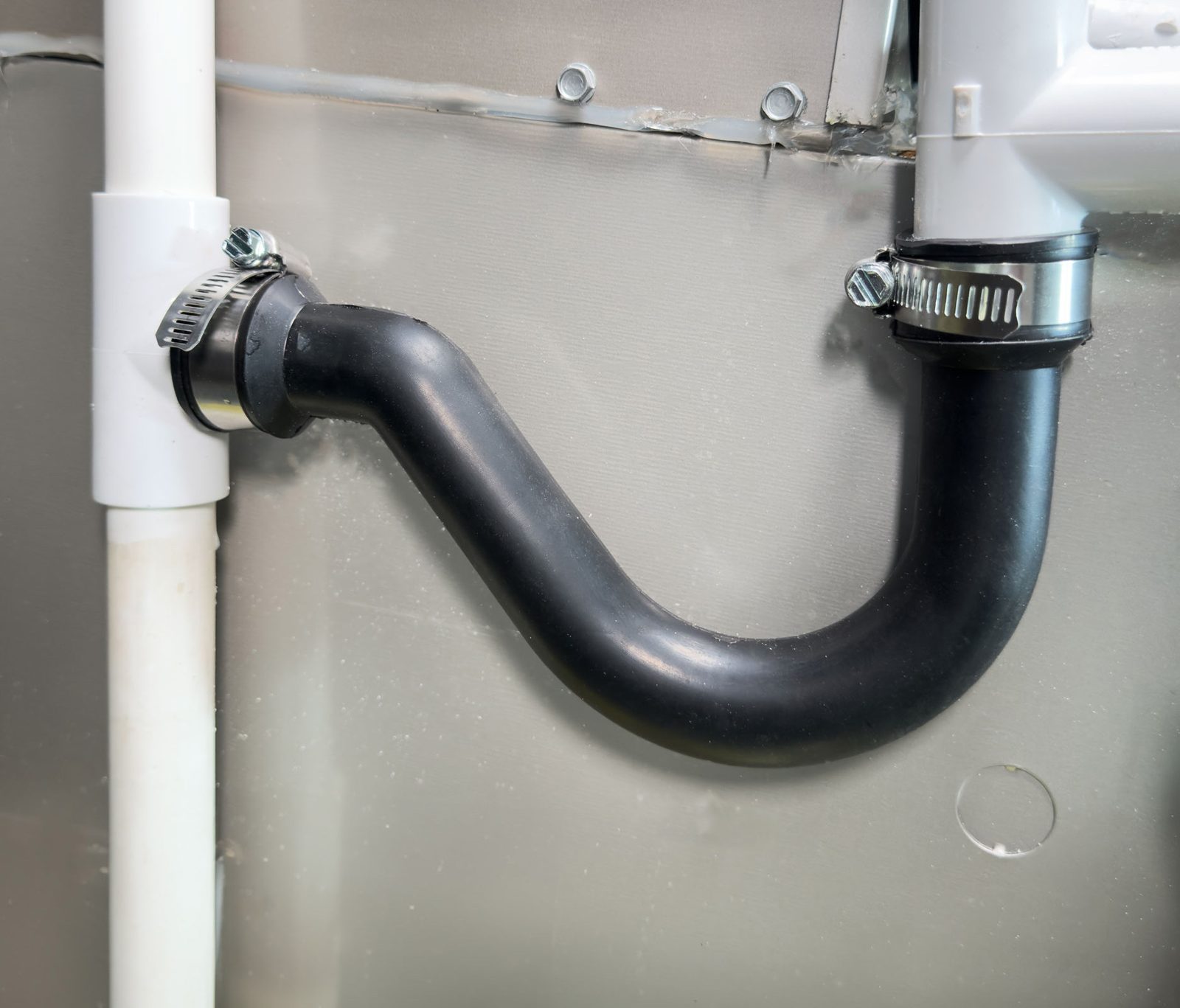 Fernco flexible condensate trap clamped onto the condensate drain of an HVAC unit