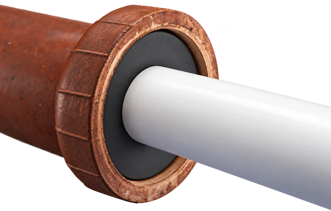 White PVC pipe sealed into a clay pipe bell with a Fernco Donut