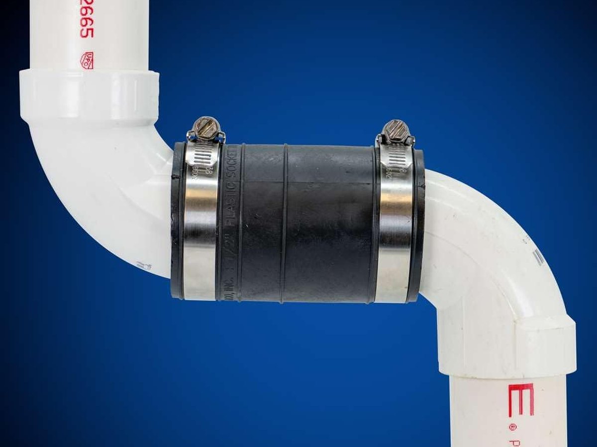 Fernco 1060-150 socket coupling joining the hubs of two PVC elbows