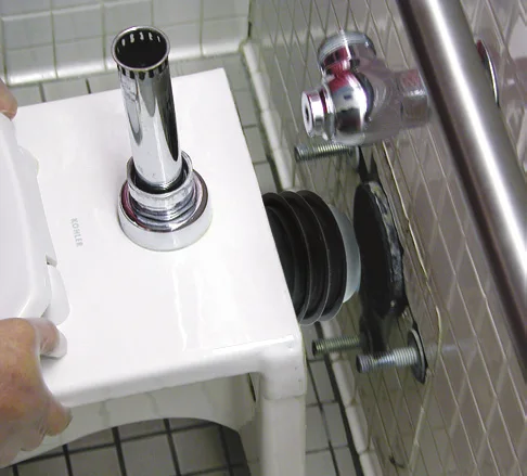 Fernco wax-free seal on the outlet of a back-outlet toilet being set onto a wall carrier
